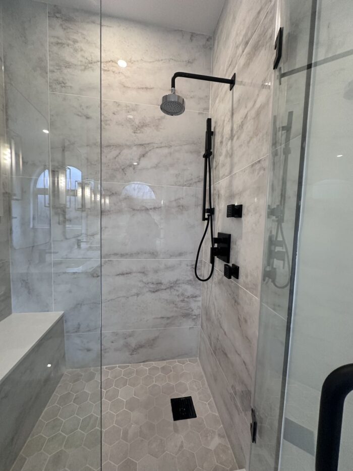 Space-efficient Markham bathroom transformation with corner shower, floating vanity, and mirrored cabinets by Lucky5 Group.